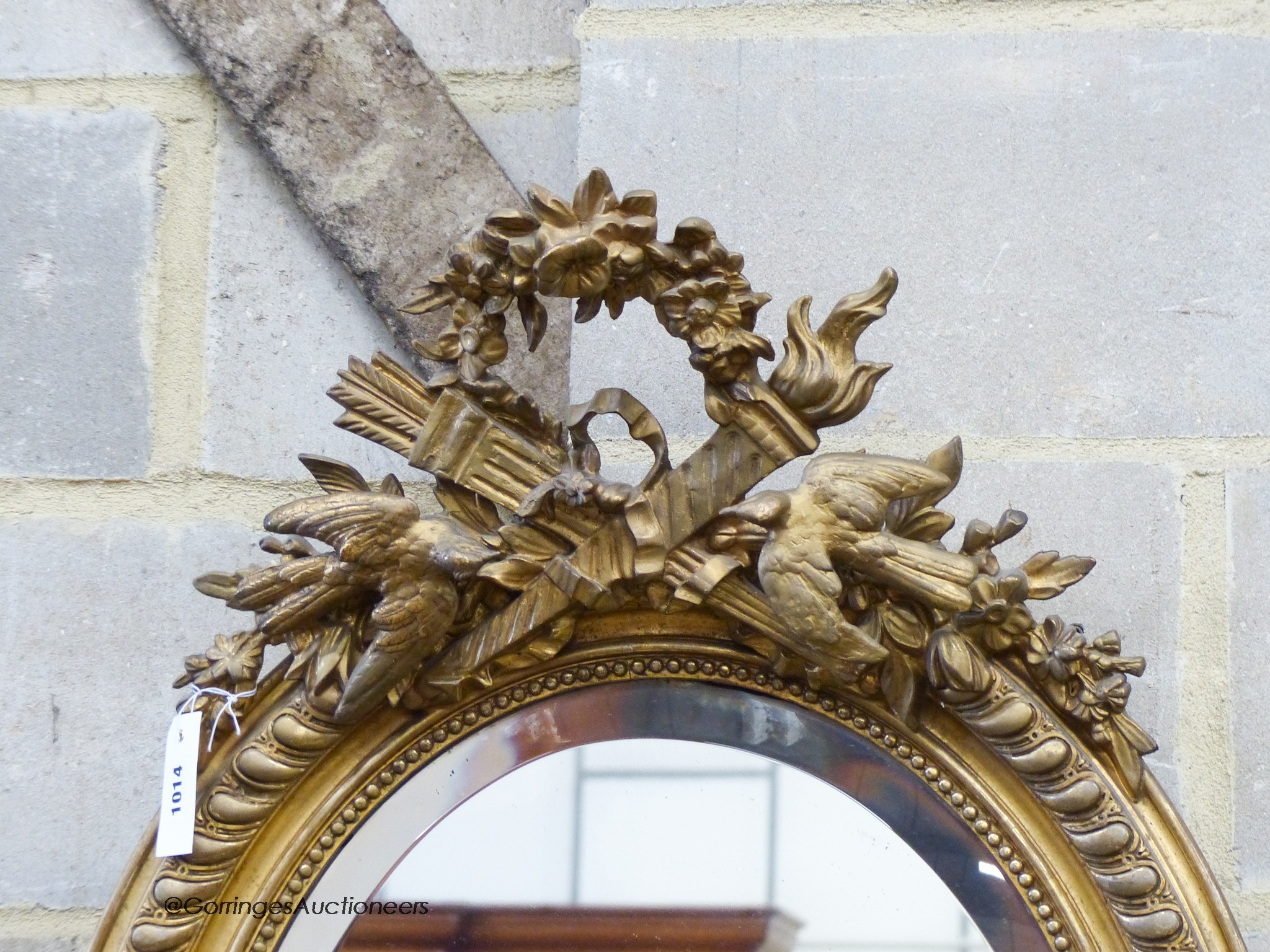 A late Victorian, gilt wood and gesso oval wall mirror, with bird pediment, W-63, H-96cm.